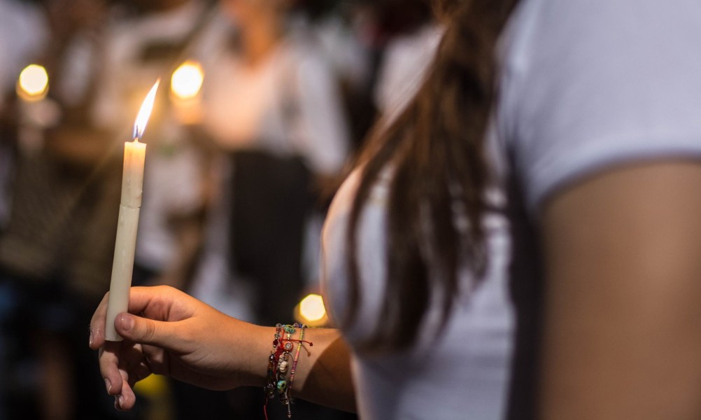 A woman holds a candle at a pro-peace demonstration in Colombia