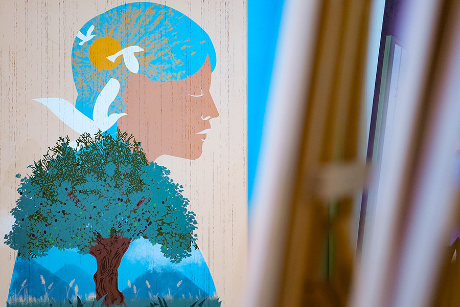 An illustration featuring a woman and a tree is on display.