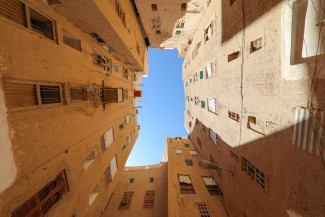 The sun shines into an urban courtyard of what it appears to be residential buildings.