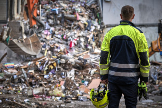 A first responder faces a destroyed building in Ukraine