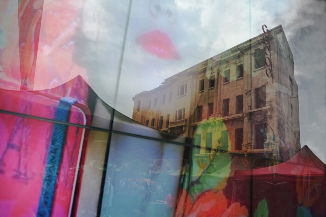 Image of a woman's face reflection on a glass showing an old destructed building from the Lebanese civil war