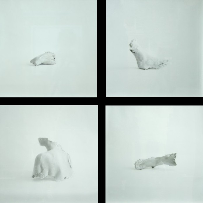 A square grid with four images, each image is a body part cast out of plaster, set on a white seamless background. There is a hand, a foot, a shoulder, and another foot.
